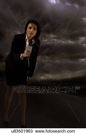Full length of news reporter in storm View Large Photo Image Stock Image - Full length of news reporter in storm . Fotosearch