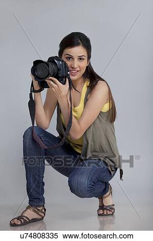 Full length of smiling female photographer with camera in her studio View Large Photo Image Stock Photography - Full length of smiling female photographer with camera in her studio . Fotosearch