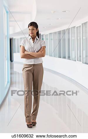 Stock Image - Full length of successful young businesswoman with arms crossed . Fotosearch