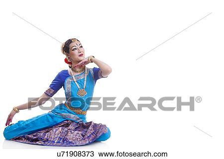 Stock Image - Full length of woman performing Bharatanatyam against white background. Fotosearch