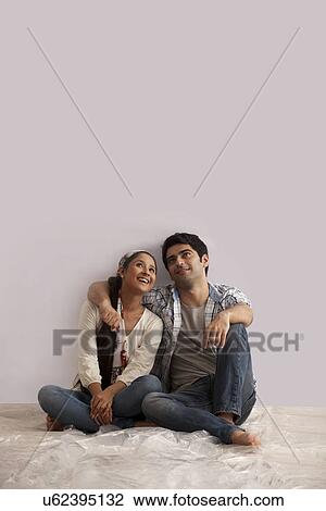 Full length of young couple looking up at copy space View Large Photo Image Stock Image - Full length of young couple looking up at copy space . Fotosearch