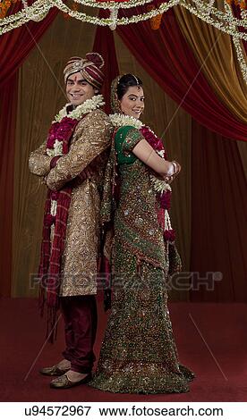 Full length of young couple standing back to back View Large Photo Image Stock Photo - Full length of young couple standing back to back . Fotosearch