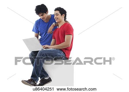 Full length of young friends using laptop over white background View Large Photo Image Stock Image - Full length of young friends using laptop over white background . Fotosearch