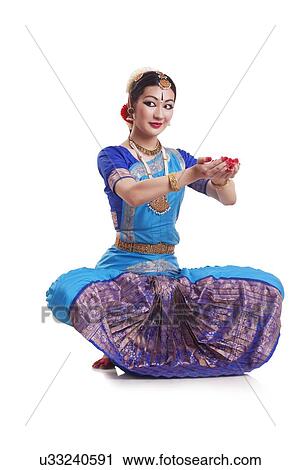 Stock Image - Full length of young woman performing Bharatanatyam over white background. Fotosearch