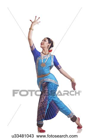Stock Image - Full length of young woman performing Bharatanatyam over white background. Fotosearch