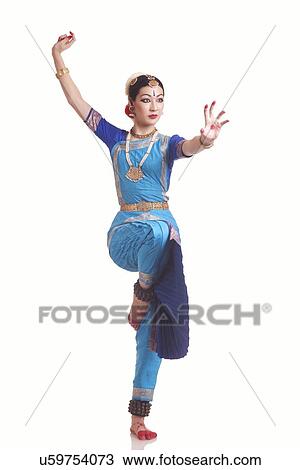 Stock Image - Full length of young woman performing classical dance on white background. Fotosearch