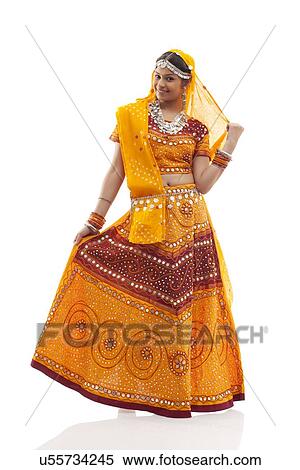 Stock Photography - Full length of young woman wearing chaniya choli isolated over white background. Fotosearch