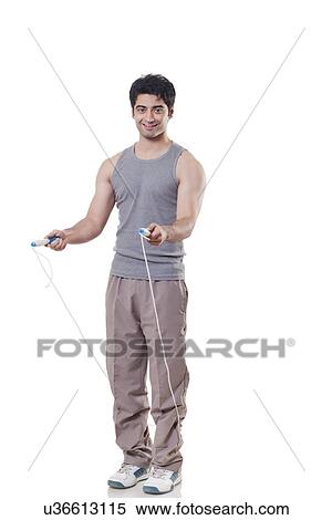Full length portrait of a young man with skipping rope over white background View Large Photo Image Stock Photography - Full length portrait of a young man with skipping rope over white background . Fotosearch
