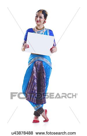 Stock Photo - Full length portrait of Bharatanatyam dancer holding blank placard over white background. Fotosearch