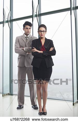 Stock Photo - Full length portrait of business people standing arms crossed in office. Fotosearch