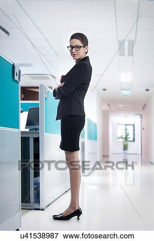 Full length portrait of confident young businesswoman in office View Large Photo Image Stock Photo - Full length portrait of confident young businesswoman in office. Fotosearch