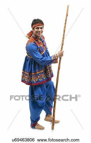Full length portrait of happy young man in traditional wear holding stick isolated over white background View Large Photo Image Stock Photograph - Full length portrait of happy young man in traditional wear holding stick isolated over white background. Fotosearch