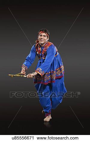 Full length portrait of Indian man in traditional wear performing Dandiya Raas isolated over black background View Large Photo Image Stock Image - Full length portrait of Indian man in traditional wear performing Dandiya Raas isolated over black background. Fotosearch