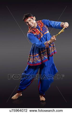 Full length portrait of young man in traditional wear performing Dandiya Raas isolated over black background View Large Photo Image Stock Image - Full length portrait of young man in traditional wear performing Dandiya Raas isolated over black background. Fotosearch