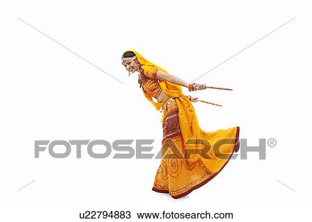 Full length portrait of young woman in chaniya choli performing Dandiya Raas over white background View Large Photo Image Stock Image - Full length portrait of young woman in chaniya choli performing Dandiya Raas over white background. Fotosearch
