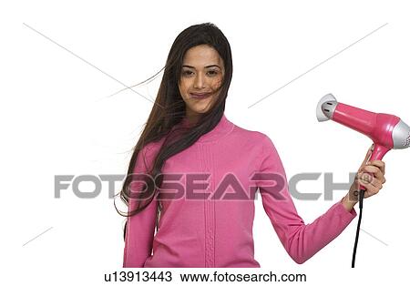 Stock Image - Girl blow drying her hair . Fotosearch