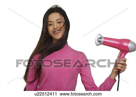 Stock Image - Girl blow drying her hair . Fotosearch