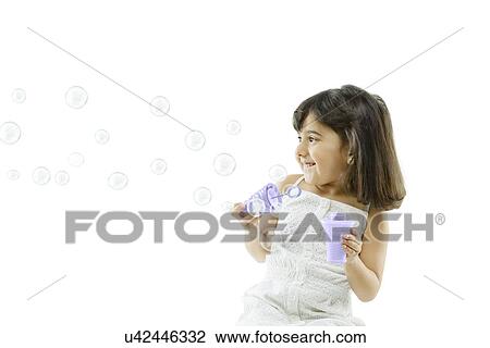 Stock Image - Girl blowing bubbles . Fotosearch