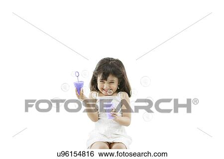 Stock Photograph - Girl blowing bubbles . Fotosearch