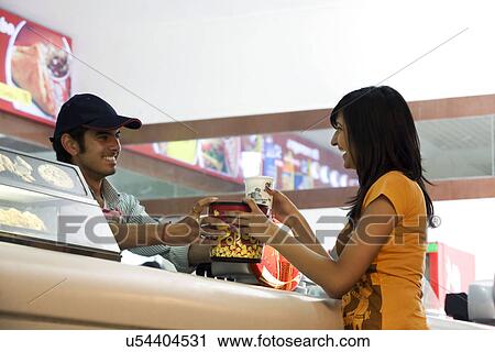 Stock Image - Girl buying popcorn and cola . Fotosearch