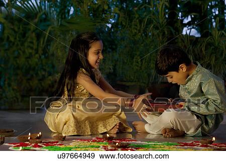 Girl giving her brother a box of chocolates View Large Photo Image Stock Photo - Girl giving her brother a box of chocolates . Fotosearch