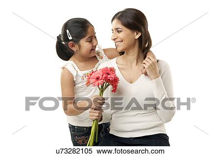 Stock Photography - Girl giving her mother flowers . Fotosearch