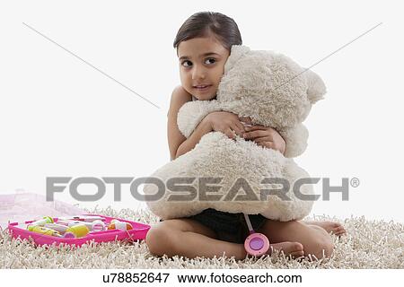 Girl hugging her teddy bear View Large Photo Image Stock Photo - Girl hugging her teddy bear . Fotosearch