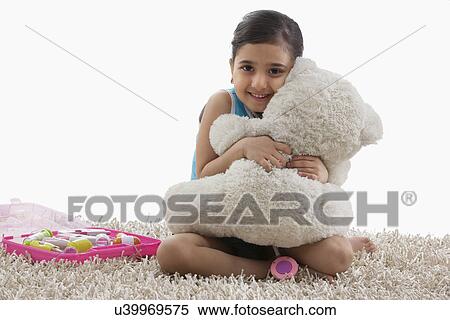 Stock Photography - Girl hugging her teddy bear . Fotosearch