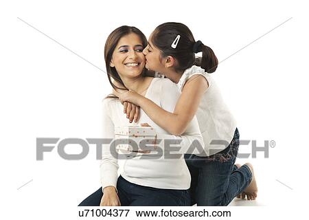Stock Photo - Girl kissing her mother on the cheek . Fotosearch