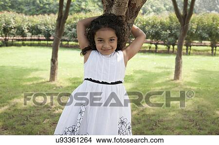 Picture - Girl leaning against a tree . Fotosearch