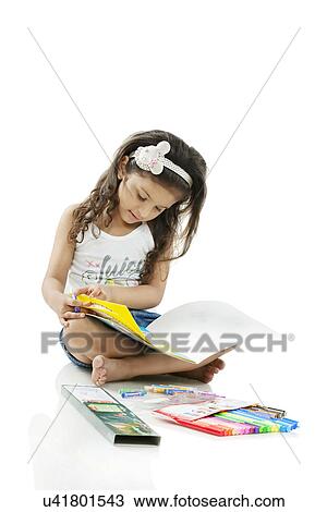 Girl looking at a colouring book View Large Photo Image Stock Image - Girl looking at a colouring book . Fotosearch