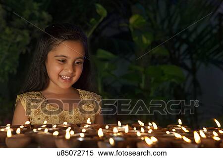 Stock Photography - Girl looking at diyas . Fotosearch