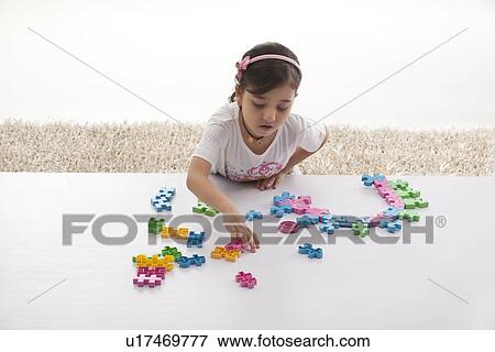 Girl looking for toy pieces View Large Photo Image Stock Photo - Girl looking for toy pieces . Fotosearch