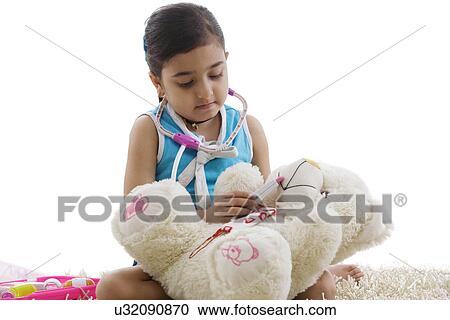 Girl playing doctor with her teddy bear View Large Photo Image Stock Image - Girl playing doctor with her teddy bear . Fotosearch