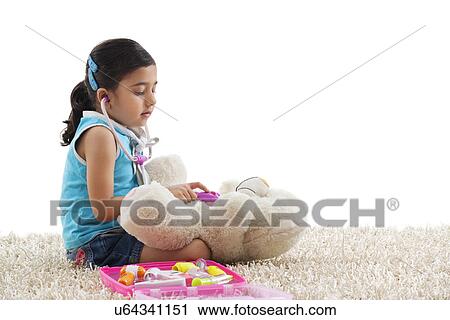 Girl playing doctor with her teddy bear View Large Photo Image Stock Image - Girl playing doctor with her teddy bear . Fotosearch