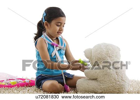 Girl playing doctor with her teddy bear View Large Photo Image Stock Image - Girl playing doctor with her teddy bear . Fotosearch