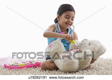 Girl playing doctor with her teddy bear View Large Photo Image Stock Image - Girl playing doctor with her teddy bear . Fotosearch