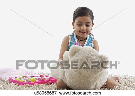Girl playing doctor with her teddy bear View Large Photo Image Stock Photo - Girl playing doctor with her teddy bear . Fotosearch