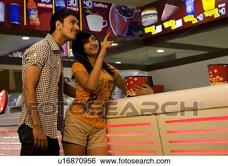 Stock Photograph - Girl pointing something out to her boyfriend . Fotosearch