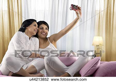 Stock Image - Girl taking a picture of herself and her mother . Fotosearch