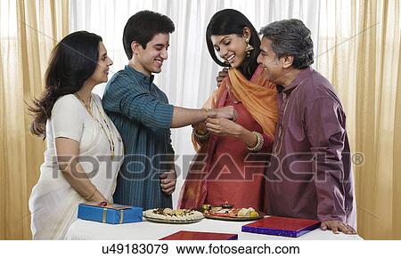 Girl tying a rakhi on her brothers hand View Large Photo Image Stock Photo - Girl tying a rakhi on her brothers hand . Fotosearch
