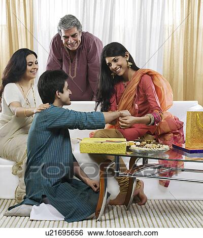 Girl tying a rakhi on her brothers hand View Large Photo Image Stock Photograph - Girl tying a rakhi on her brothers hand . Fotosearch