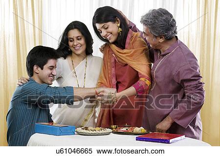 Girl tying a rakhi on her brothers hand View Large Photo Image Stock Photography - Girl tying a rakhi on her brothers hand . Fotosearch