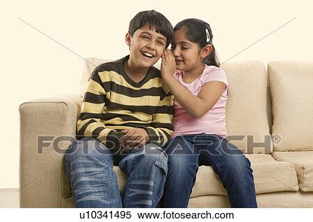Girl whispering in her brothers ear View Large Photo Image Stock Photography - Girl whispering in her brothers ear . Fotosearch