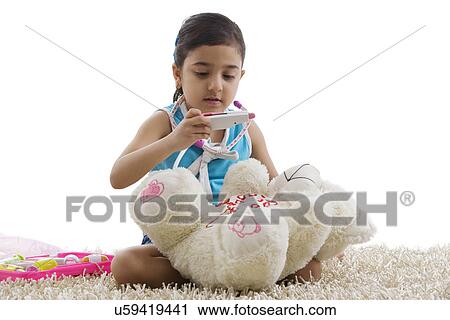 Stock Image - Girl with a toy thermometer . Fotosearch