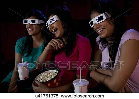 Girls watching a movie with 3-D glasses View Large Photo Image Stock Photography - Girls watching a movie with 3-D glasses . Fotosearch