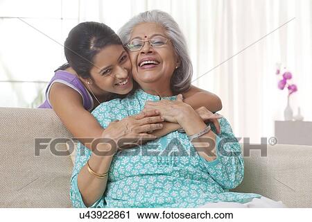 Stock Image - Granddaughter hugging her grandmother. Fotosearch