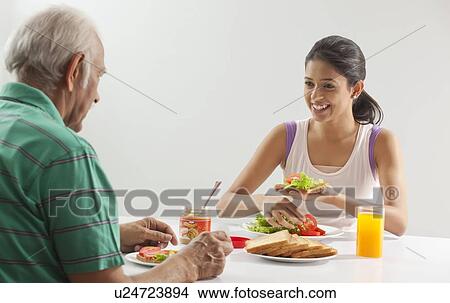 Grandfather and granddaughter eating breakfast View Large Photo Image Picture - Grandfather and granddaughter eating breakfast. Fotosearch