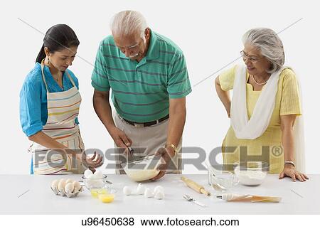 Grandfather and granddaughter working in the kitchen while grandmother looks on View Large Photo Image Stock Photo - Grandfather and granddaughter working in the kitchen while grandmother looks on. Fotosearch