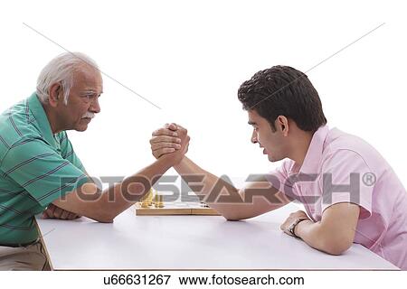 Stock Photo - Grandfather and grandson doing arm wrestling. Fotosearch